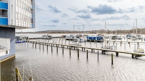 Een jachthaven met aan wal liggende boten, een steiger en een gebouw met een blauwe gevel.