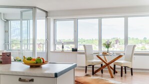 Een moderne keuken met een eethoek, grote ramen en uitzicht op het landschap.