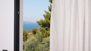 A room with a view of the sea, a window with a black frame, and a curtain. - Safir Luxury Suites (Sarandë)
