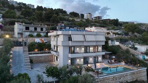 A modern multi-story building with a rooftop pool and solar panels. - Safir Luxury Suites (Sarandë)
