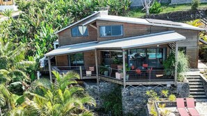 Een modern huis met een overdekte patio, stenen trappen en een zwembad.