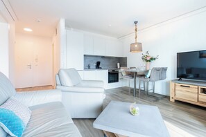 Ein modernes Wohnzimmer mit einer Couch, einem Couchtisch und einem Fernseher.