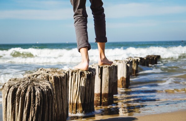 A person standing on wooden posts by the ocean. - White Villa Grömitz apartment 11. sea view. Balcony. Close to the beach (Grömitz)