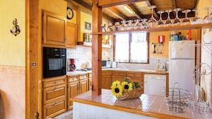Una cocina con armarios de madera, estufa, lavaplatos y refrigerador.