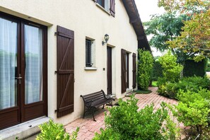 A building with a bench outside, a paved walkway, and greenery. - Holiday Home With Swimming Pool (Sainte-Eulalie-en-Born)