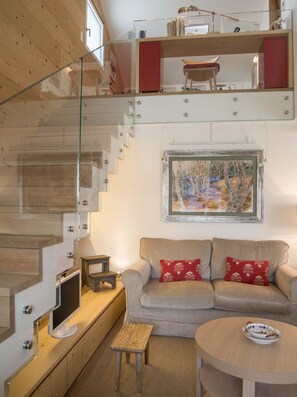 Ein modernes Interieur mit Treppe, Sofa, Tisch und einem Gemälde.
