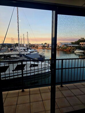 A marina with boats docked, a clear sky, and a view of buildings in the distance. - Bayview Fishing Paradise | NT Luxury Marina Escape | Sleeps 6 (Bayview)