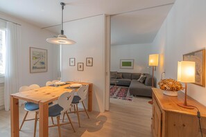 Eine moderne Wohnung mit Essbereich, Wohnzimmer und Küche.
