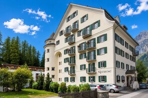 Ein mehrstöckiges Hotel im klassischen europäischen Stil, mit Balkonen und einer gut sichtbaren Restaurantschild.