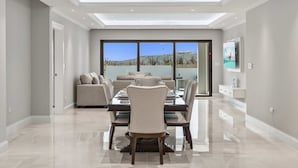 Comedor con una mesa de vidrio, sillas y vista al paisaje.