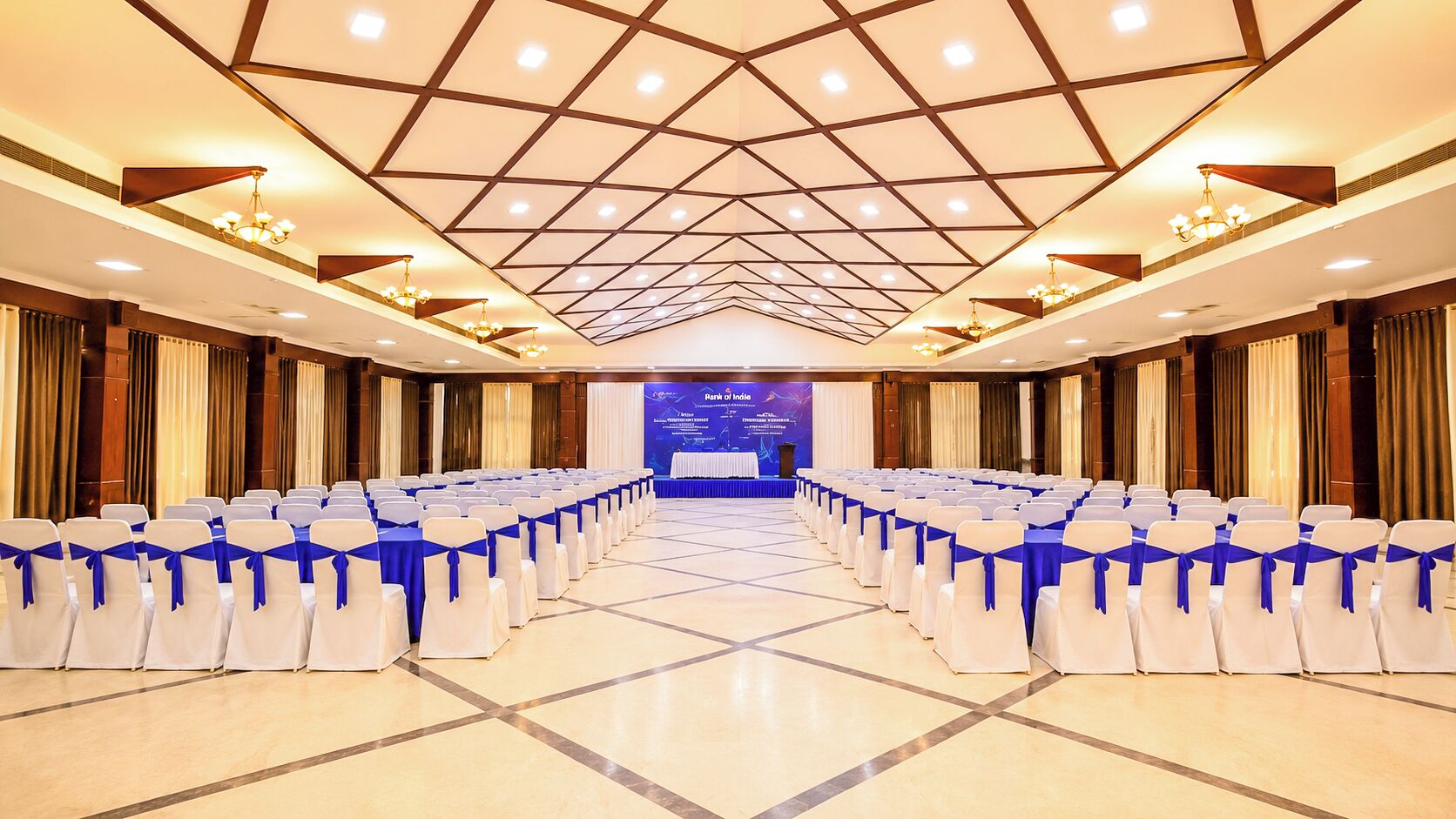 A conference room with rows of chairs, a stage, and a banner.