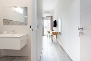 Ein modernes Badezimmer mit Waschbecken, Spiegel und Handtuchhalter.