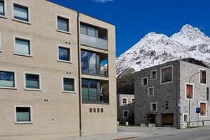 Ein modernes Gebäude mit mehreren Balkonen und einem Blick auf die Berge.