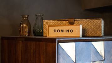A wooden box with the name 'DOMINO' on it, placed on a surface with two glass vases.