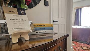 A hotel reception desk with a welcome sign, a menu, and a stack of books.