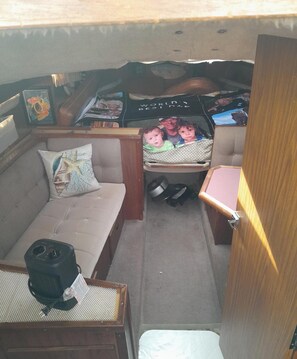 A compact living space with a sofa, a small table, a child's play area, and a kitchenette.