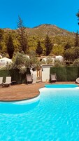 Una piscina al aire libre de temporada, sombrillas