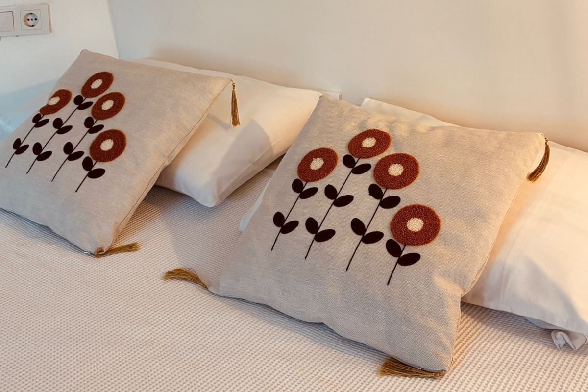 Un dormitorio con una cama, almohadas y tres obras de arte colgadas en la pared.