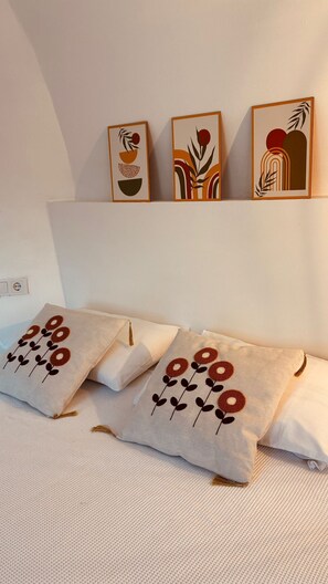 A bedroom with a bed, pillows, and three wall-mounted artworks. - Vita Nova Hotel (Kumluca)