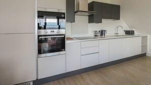 Eine moderne Küche mit Einbaugeräten, einem großen Fenster und Blick ins Freie.