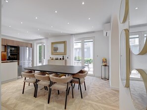 Eine moderne Küche mit Essbereich, inklusive großem Tisch und sechs Stühlen.