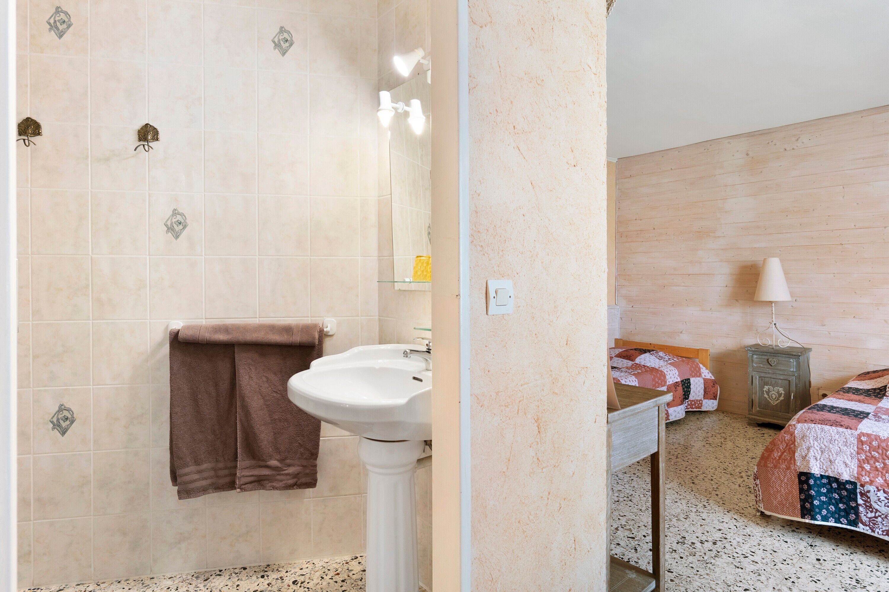 A bathroom with a sink, towel rack, and shower.