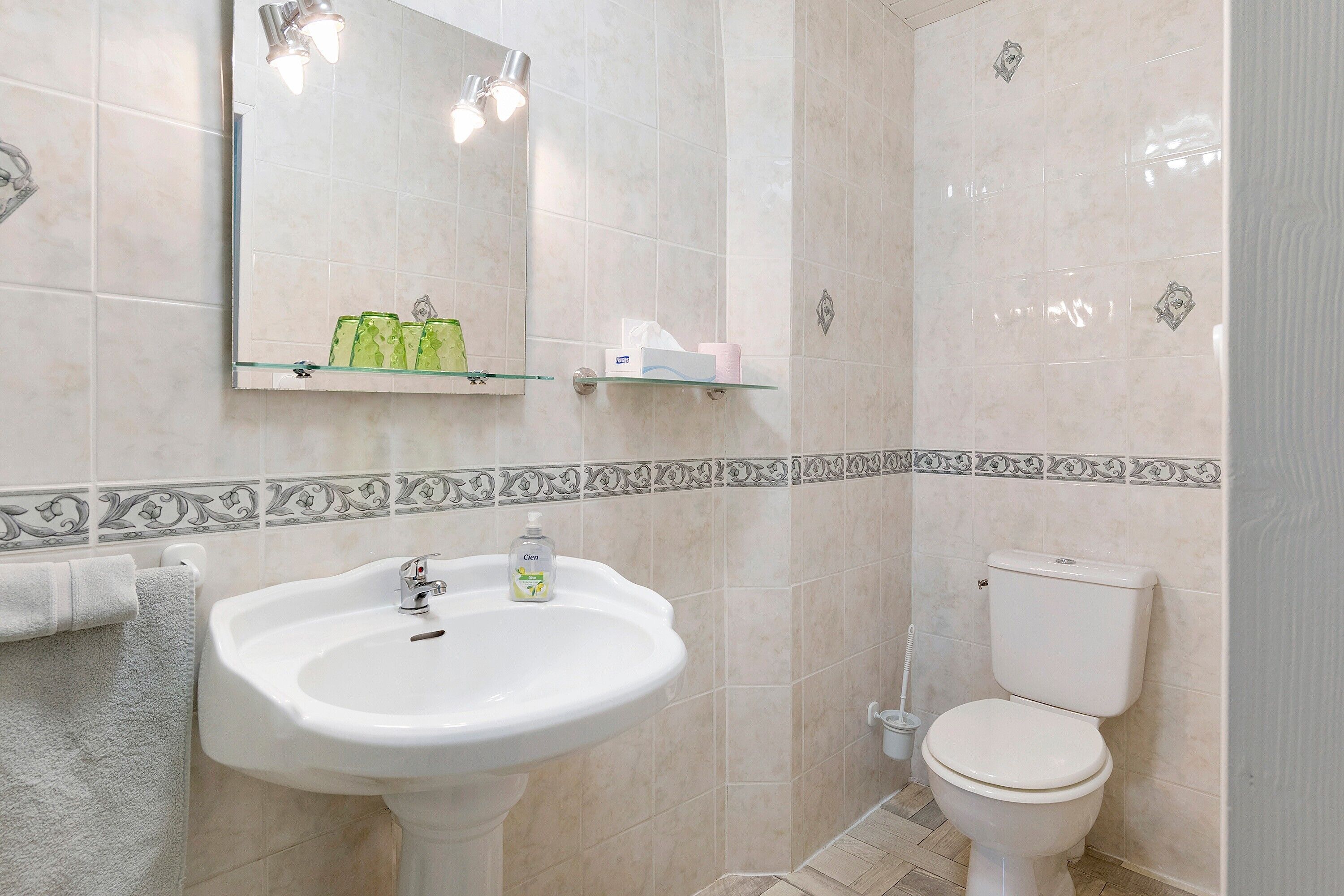 Une salle de bain avec un lavabo, des toilettes et un miroir.
