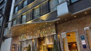 A multi-story hotel with a modern facade, large windows, and a prominent entrance with a canopy. - Hotel Ini (Madrid)