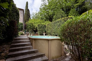 A stone staircase leading to a hot tub surrounded by lush greenery and a tall tree. - Villa Roocello, charming restored olive mill, with (Capannori)