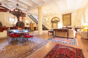 A spacious living area with a dining table, a chandelier, a staircase, and a large rug. - Villa Roocello, charming restored olive mill, with (Capannori)