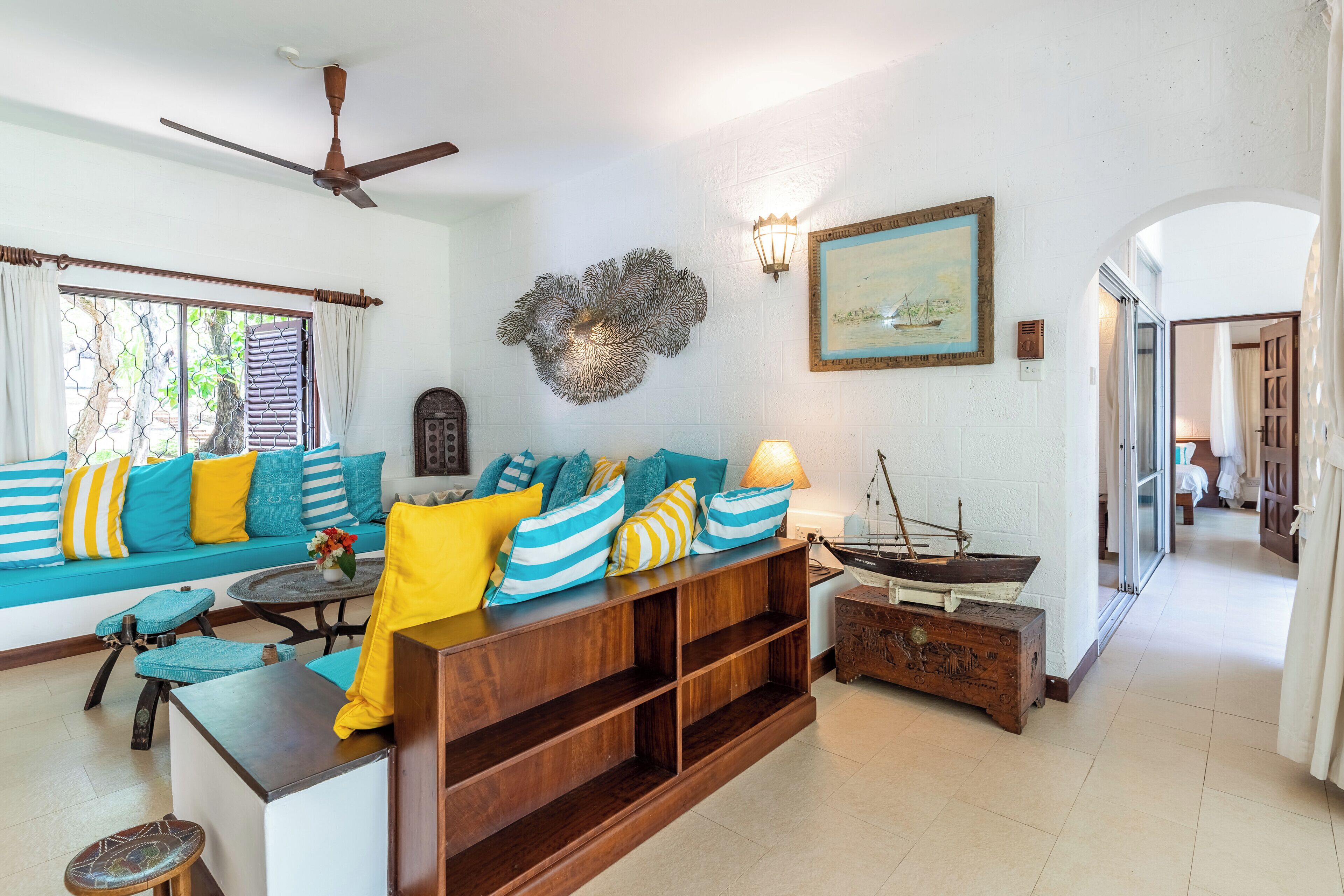 A living room with a sofa, coffee table, and a decorative ship model.