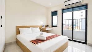 A hotel room with a bed, bedside table, window, and air conditioning unit. - Starlake Residence  (Hanoi)