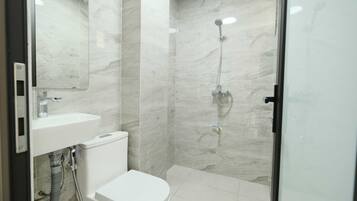 A bathroom with a toilet, sink, and shower.