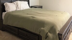 Una camera da letto con un letto, un comodino e una cassettiera.
