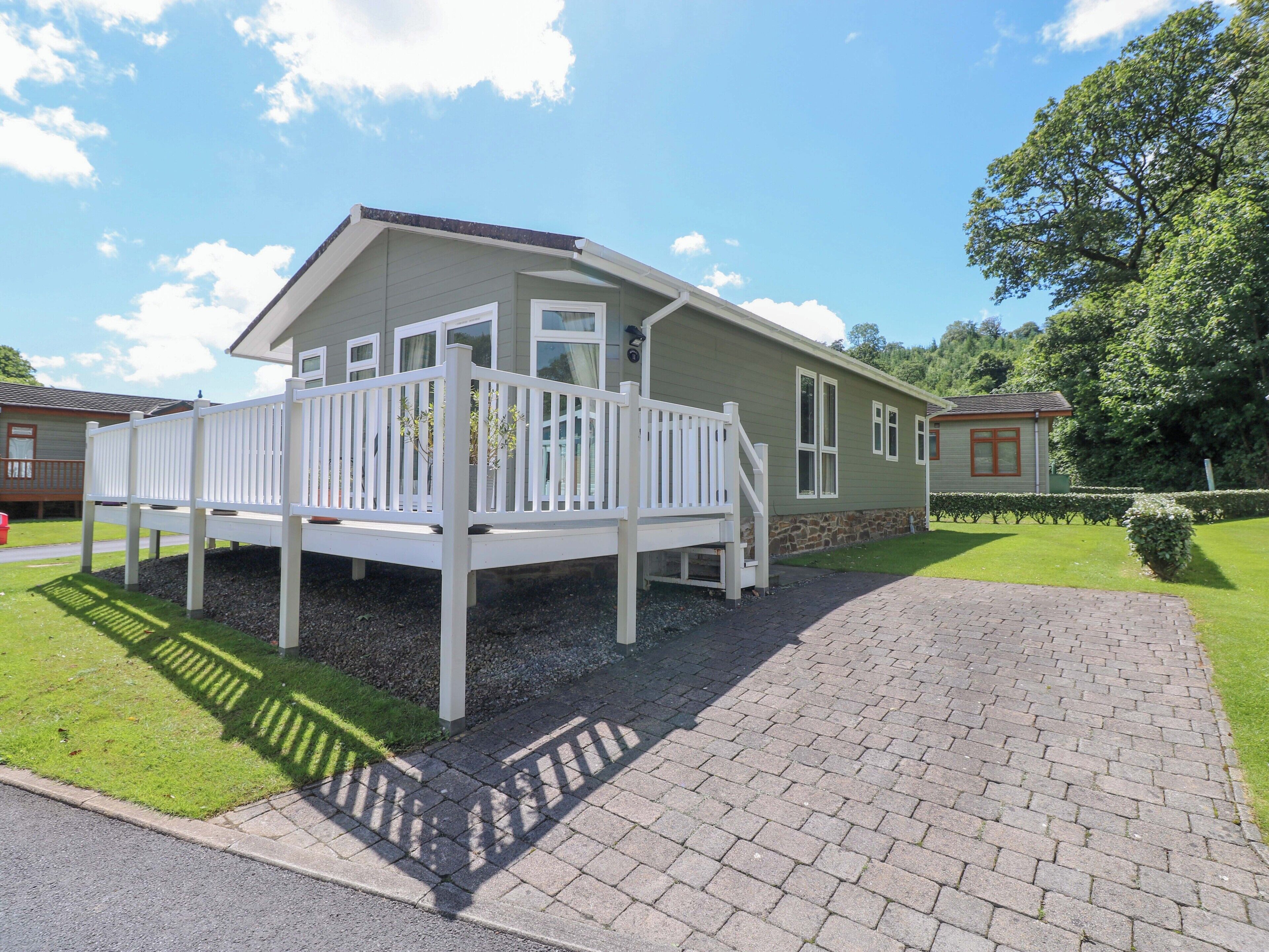 A single-story house with a porch, a driveway, and a well-maintained lawn.