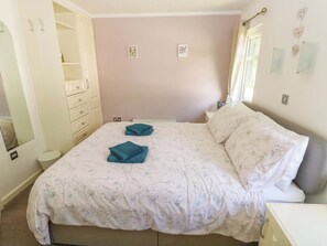 A bedroom with a bed, a dresser, a mirror, and a nightstand. - Serenity (Narberth)
