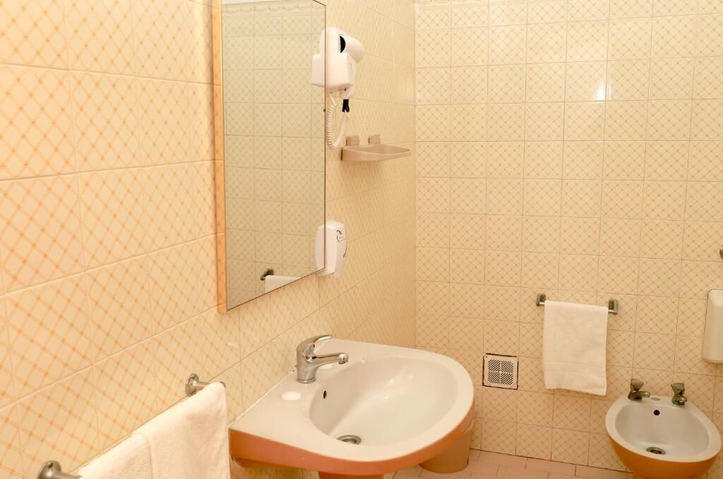 Un baño con lavamanos, espejo y dos lavabos.