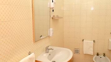 Un baño con lavamanos, espejo y dos lavabos.