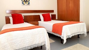 Two beds with white linens and red pillows, a wooden headboard, and a wooden wardrobe. - Braga Restaurante e Residencial (Lourinha)