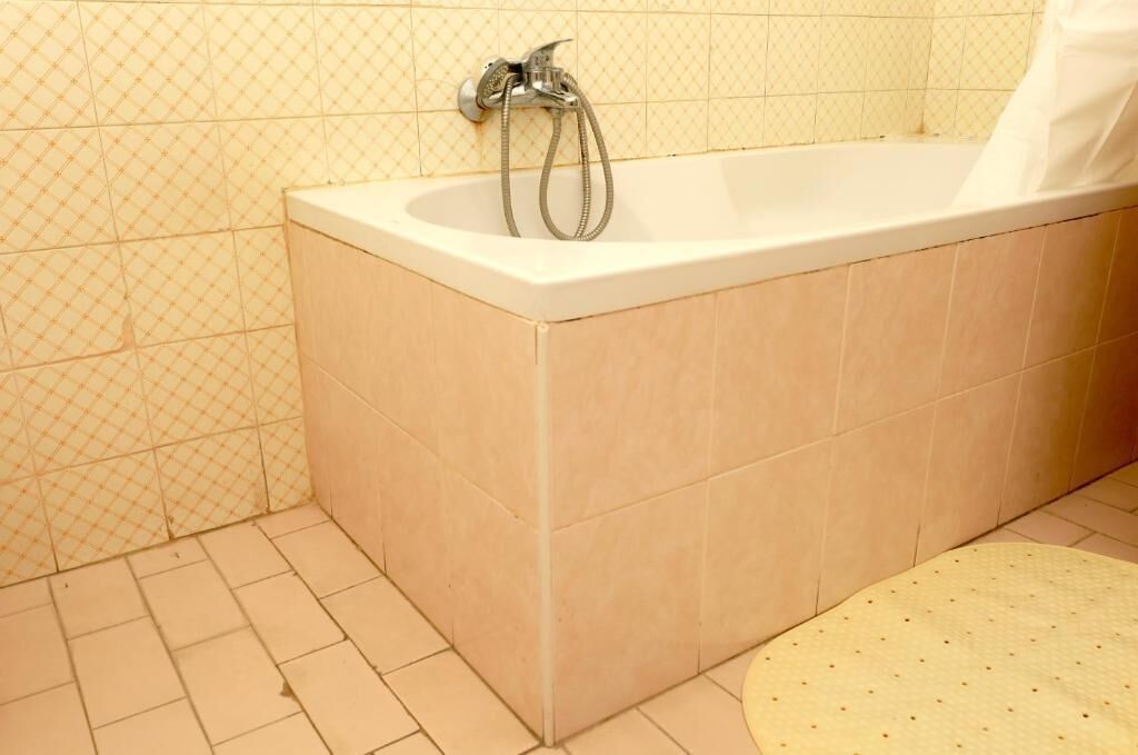 A bathroom with a bathtub, a shower, and a tiled floor.
