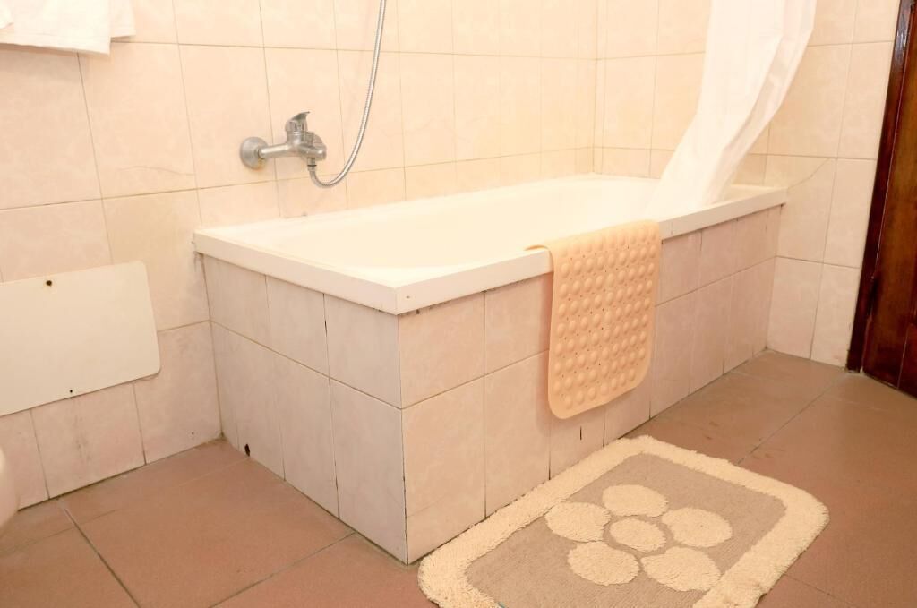 A bathroom with a bathtub, a shower, and a towel rack.