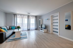 Ein modernes Wohnzimmer mit einer Couch, einem Fernseher und einem Couchtisch.