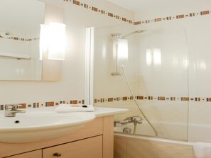 A bathroom with a sink, mirror, shower, and tiled walls. - Alpine Retreat in Divonne-les-bains (Herbeys)