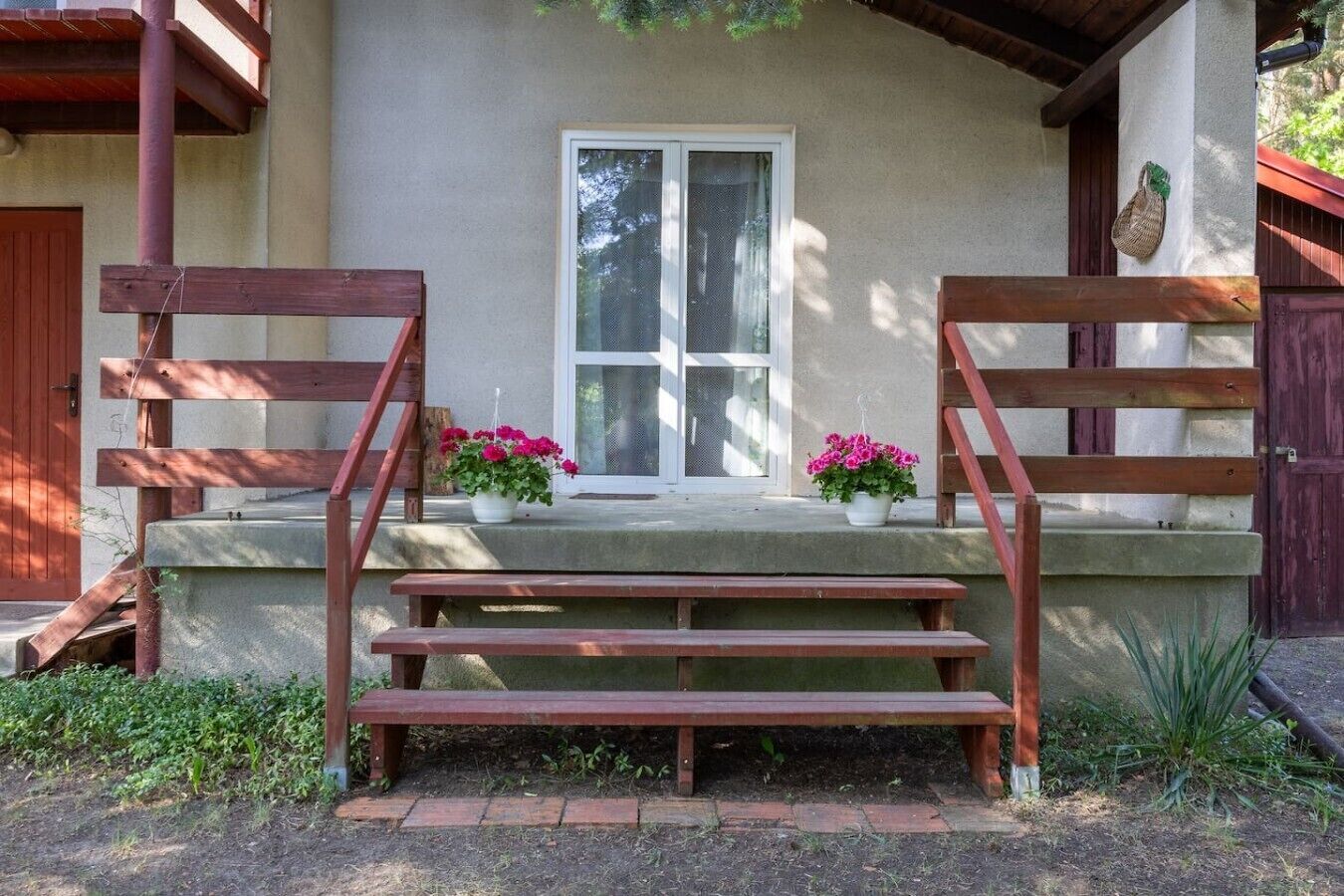 A building with a porch, steps, and a window.