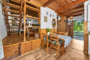A wooden interior with a dining table, chairs, and a view of the outdoors. - Adamów Family Country Retreat - 75m2, Terrace (Adamów-Wieś)