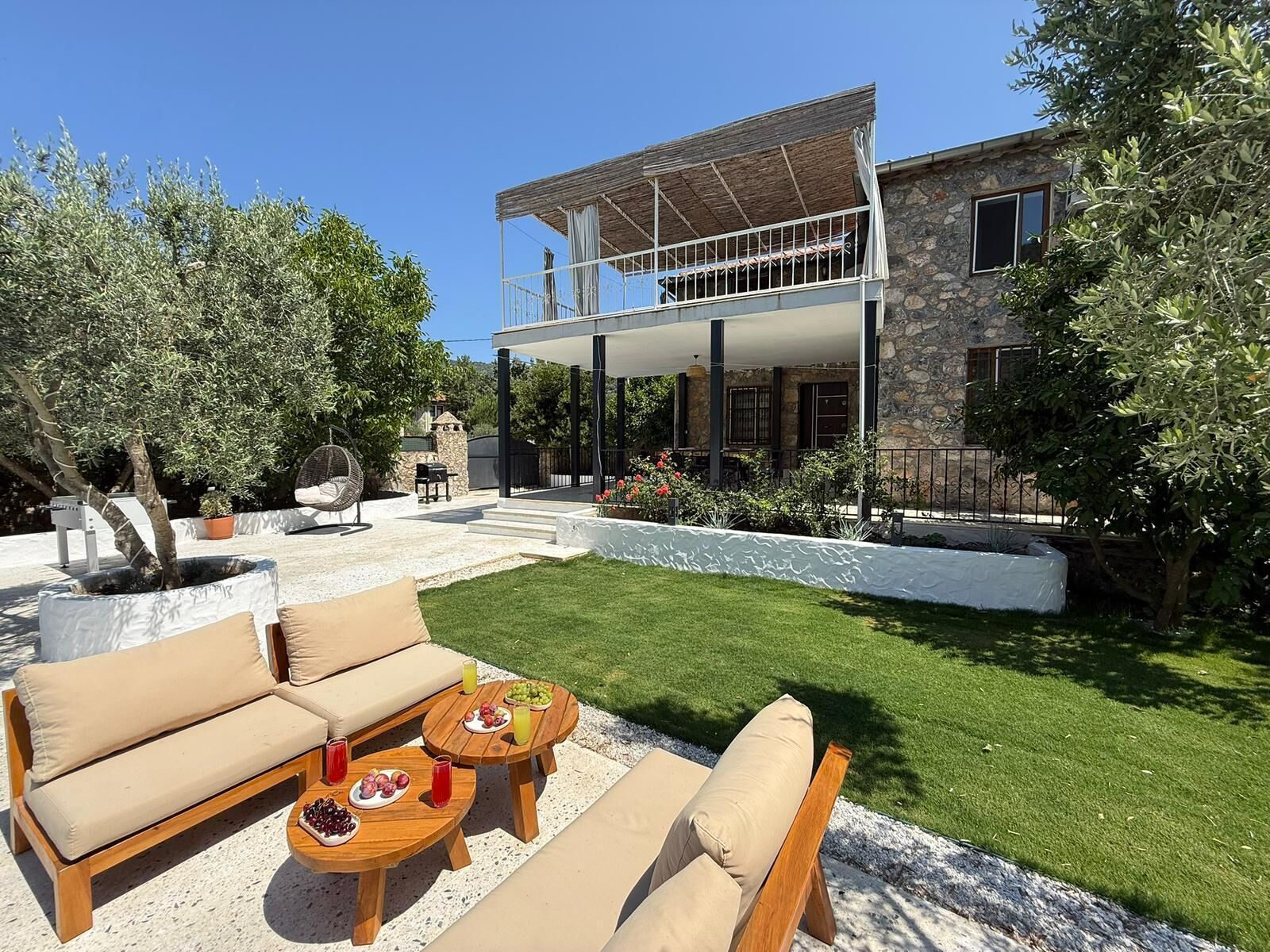 Une maison dotée d’un patio couvert, de meubles d’extérieur et d’une pelouse bien entretenue.