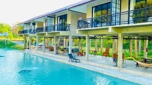 Um hotel com piscina, área de estar externa e varandas.