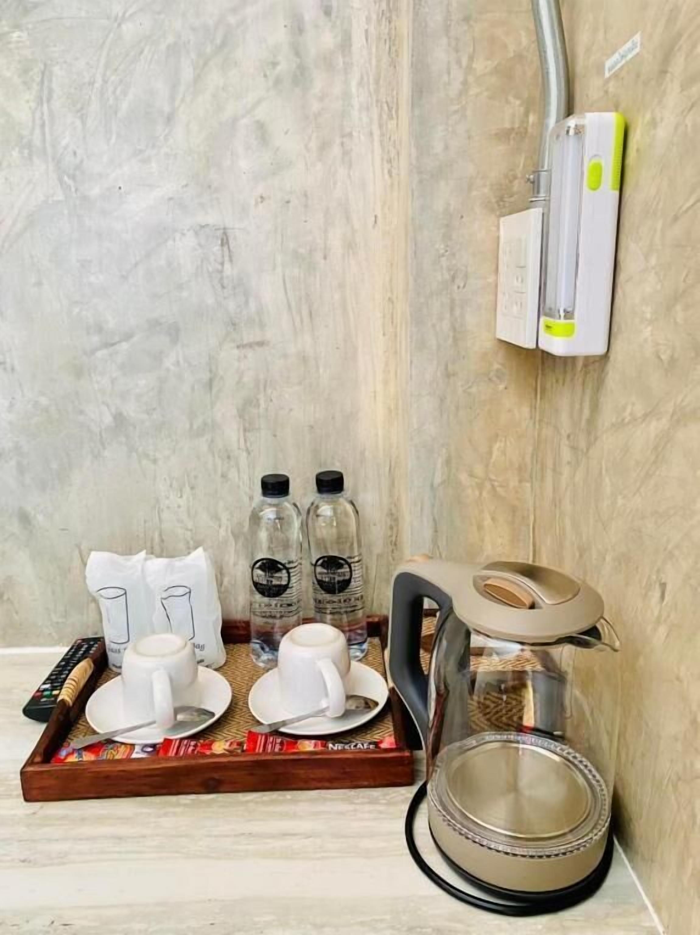 Un plateau de petit-déjeuner avec une théière, des tasses et une machine à café.