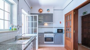 Una cocina con un lavamanos, estufa, horno y armarios.