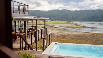 A poolside area with a view of a river and hills.
